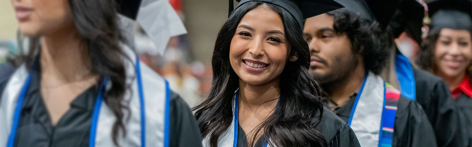 Girl looking towards camera in commencement regalia